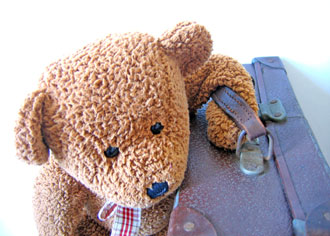 Traveling with children teddy bear and a suitcase