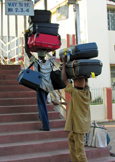 Men carrying luggage on their heads